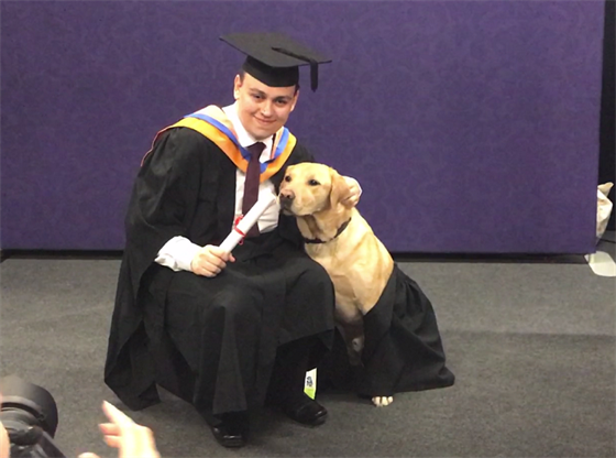 Charles and Carlo the guide dog get a DMU graduation paw-trait