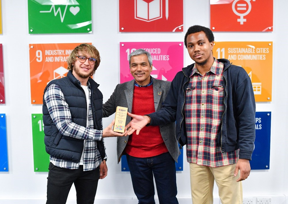 Oskar Sienkiewicz, left, and Kofi Amanfo, right, are presented with a Climate Award by Carlos Islam, United Nations Communications Officer, at a previous ceremony