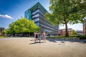 Students walking in the sun outside the Hugh Aston building