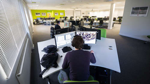 Wide shot of the Game Art studio with a student working on a dual-monitor computer