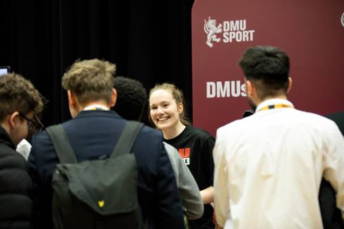 Students talking to a member of the DMU sports team about sports opportunities